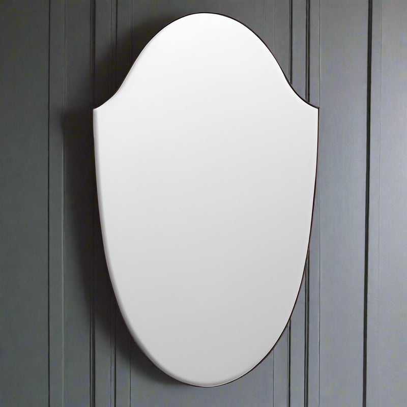 Large shaped mirror without a frame, this large mirror is shield shaped, without an outer frame to allow the mirror to disperse the light in any room without the restrictions of a frame. Perfect for a bathroom or dressing room, it would also work well in a living room or a hall, the full metre height flashing light from the wall.