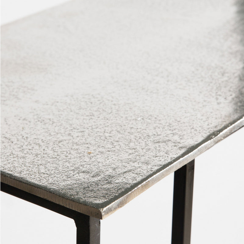 Sofa table in aluminium beaten metal with black iron legs, made to slide under a sofa. Tables in this shape are perfect space savers and in this fabrication adding glamour to any room.