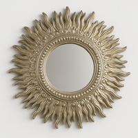 Decorative sun-shaped mirror with a gold finish on a white background