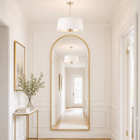 Tall arched mirror with gold frame in a hallway