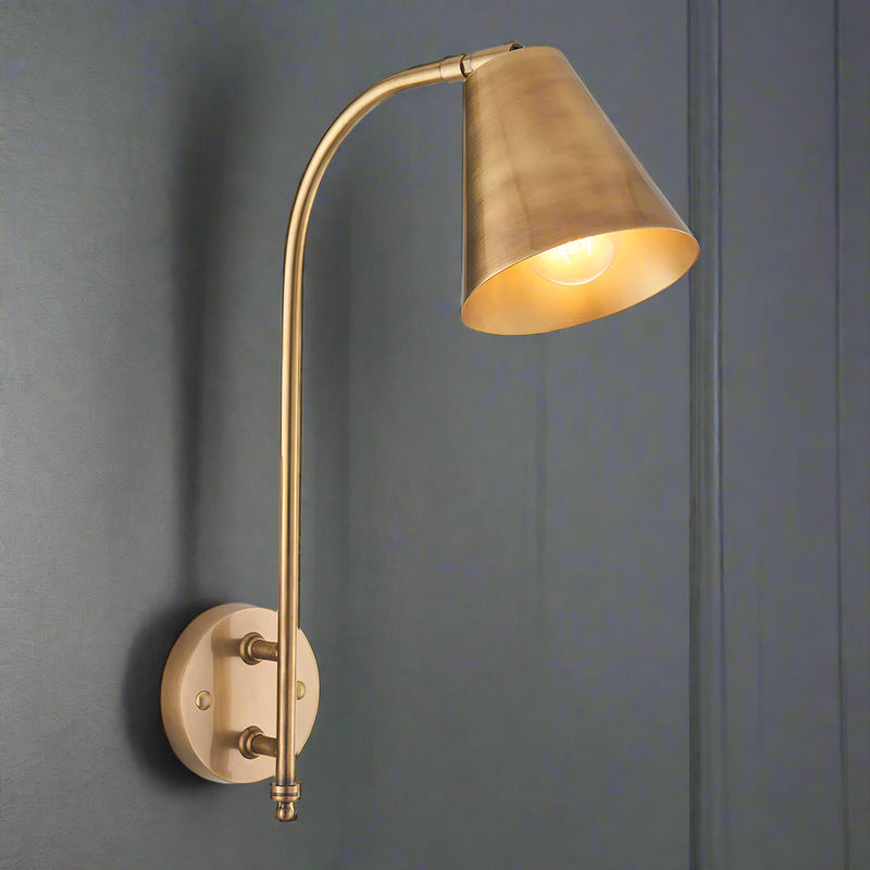 Gold wall-mounted lamp on a gray wall