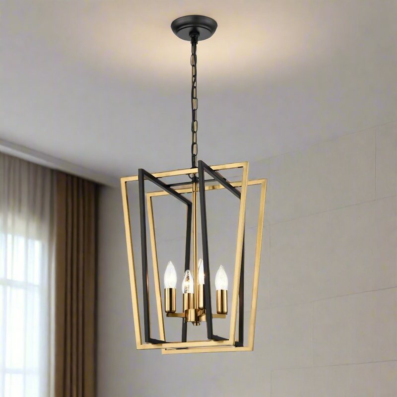 A tall matt black and brass lantern with four light fittings, suspended by a chain, displayed against a neutral background.