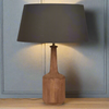 A tall, sleek wooden lamp base with a large black linen shade. An unusual, stunningly shaped lamp, a natural, statement light for your home. Perfect to light your hall on a wooden console table,