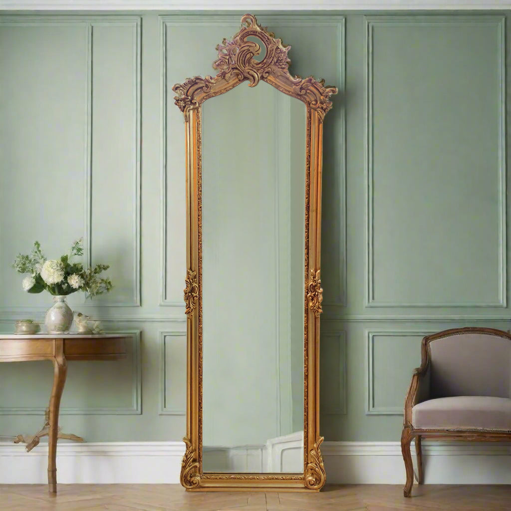Tall giltwood mirror with ornate swag. A classic gold dressing mirror, tall and narrow, perfect in a hall, entry way, bedroom or dressing room. The gilt swag decoration to the top of this mirror adds to the grandeur of this piece.&nbsp; Crafted and carved from solid wood with a rich gilt finish, a really luxurious addition to your room. Ideal in a bedroom to add light and perspective and a perfect dressing room mirror.