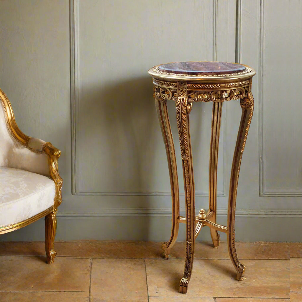 Ornate curved gilt wood based stand with marble top in a Louis style.&nbsp; The base is richly carved and covered in gold, the veined red marble is inset into the top of the stand.&nbsp; The stand has four slender cabriole legs, fluted and carved with acanthus leaves and classical motifs. The legs are then connected with a gilt stretcher to add stability. These stands are used to display a highly decorative work of art or can be used as plant stands. They will lift any room in which they are placed and work