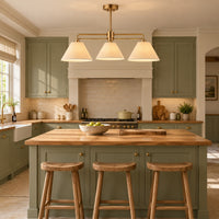Three light linen shaded pendant over a kitchen island.