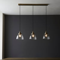 3 light, linear pendant in clear glass with antique brass metal accents and ceiling plate. To add light over your kitchen island or dining area. A real design led addition to your dining room or kitchen.