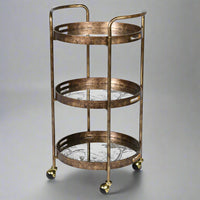 A gilt drinks trolley withe three mirrored trays, that can be used independently to the trolley.&nbsp; The trays are mirrored glass with a tranquil waterside scene in gilt,&nbsp; the frame of the trolley is brushed gilt metal and the whole thing is set on four castors.&nbsp; Trolley such as these are called 'drinks' trolleys, but can also be used to display all your toiletries in a bathroom, to display plants in a conservatory, they have diverse uses.&nbsp; Not forgetting three useful trays.
