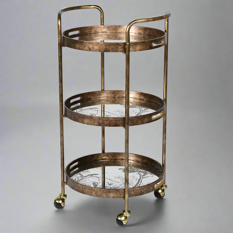 A gilt drinks trolley withe three mirrored trays, that can be used independently to the trolley.&nbsp; The trays are mirrored glass with a tranquil waterside scene in gilt,&nbsp; the frame of the trolley is brushed gilt metal and the whole thing is set on four castors.&nbsp; Trolley such as these are called 'drinks' trolleys, but can also be used to display all your toiletries in a bathroom, to display plants in a conservatory, they have diverse uses.&nbsp; Not forgetting three useful trays.