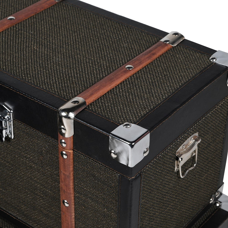 Set of four black trunks in varying sizes.&nbsp; The three larger trunks are banded with wooden straps and nickel studs. Trunks are such a useful item of furniture, perfect for storage but can also be used as a side table in a living room, bedroom study or for storing shoes in a hall. The black hessian covering will work in so many interiors