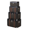 Set of four black trunks in varying sizes.&nbsp; The three larger trunks are banded with wooden straps and nickel studs. Trunks are such a useful item of furniture, perfect for storage but can also be used as a side table in a living room, bedroom study or for storing shoes in a hall. The black hessian covering will work in so many interiors
