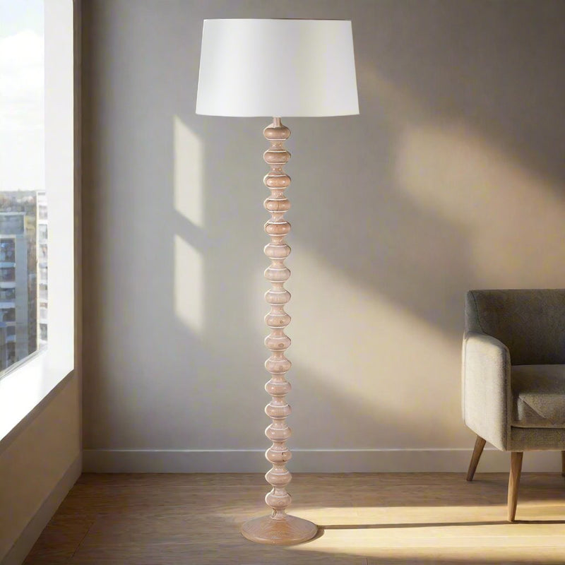 Turned wooden floor lamp, in a natural wood. A great Scandi look with white linen shade. A simple contemporary lamp. 