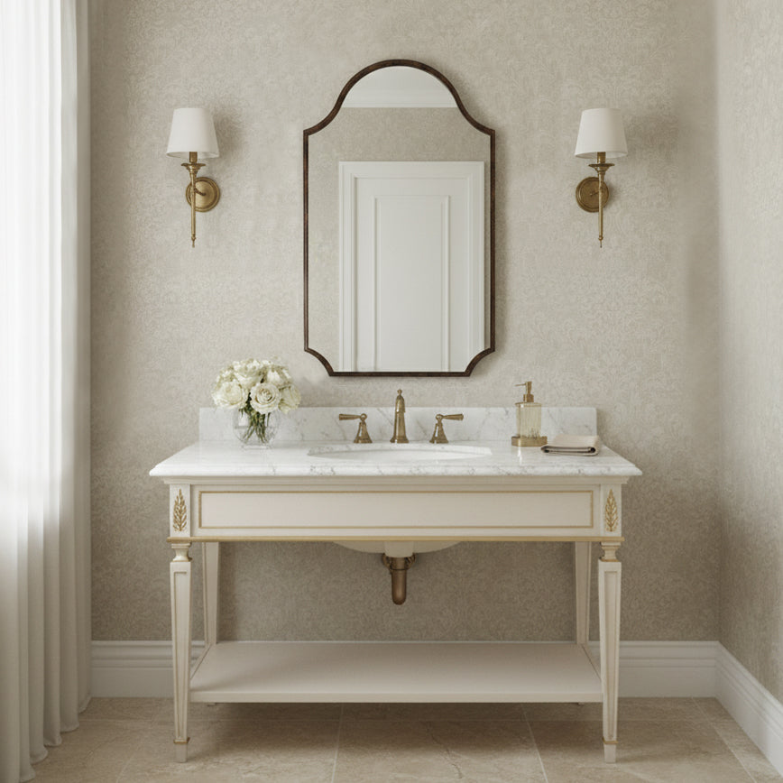 Bathroom vanity with marble countertop, sink, and mirror against a beige wall.