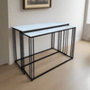 Marble topped console tables on a black iron metal base. These sturdy pieces where the white marble contrasts stunningly against simple black iron legs. 