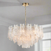 Icicle shard chandelier with textured glass panels at varying heights to refract the lights. It has 16 lights and aged brushed brass metal fittings.