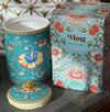 Handcrafted ceramic candle jar with turquoise floral design and gold detailing, scented with Aloe and Sea Salt.