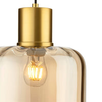 Close-up of amber glass pendant light featuring a brushed gold metal top and visible filament bulb, perfect for modern kitchen decor.