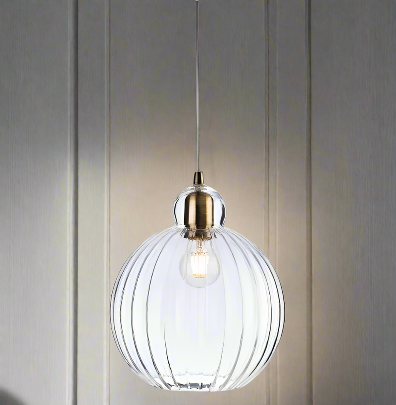 A round ribbed glass pendant light with antique brass metalwork. A pretty, round ribbed shape which would work well in a kitchen, cloakroom or even in a bedroom. The ribbed glass subtly diffuses the light and reduce glare. 