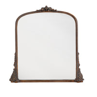 Antique-style overmantle mirror with ornate bronze-finished frame and decorative carved detailing.