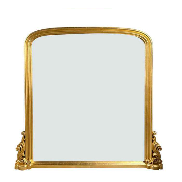 An ornate gold-framed wall mirror with a rounded top and decorative carved corners, 