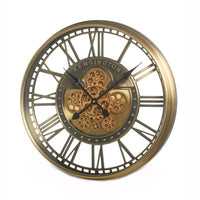 Finished in warm antique gold tones, the open-frame design reveals intricate moving cogs at the centre, giving the clock depth and character.