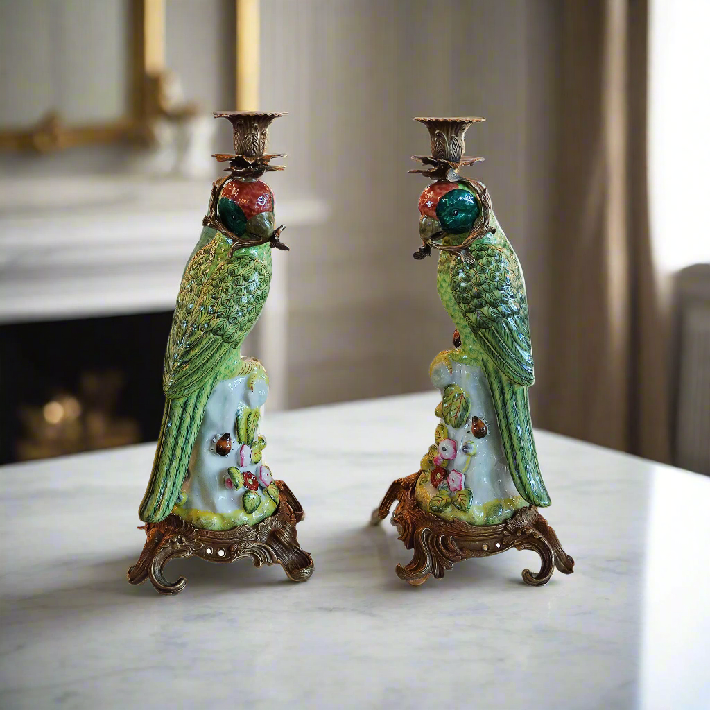 Pair of bronze and coloured porcelain parrot candle holders on ornate bases.