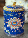Handcrafted blue ceramic scented candle jar with floral design and gold detailing, scented with Black Cedar.