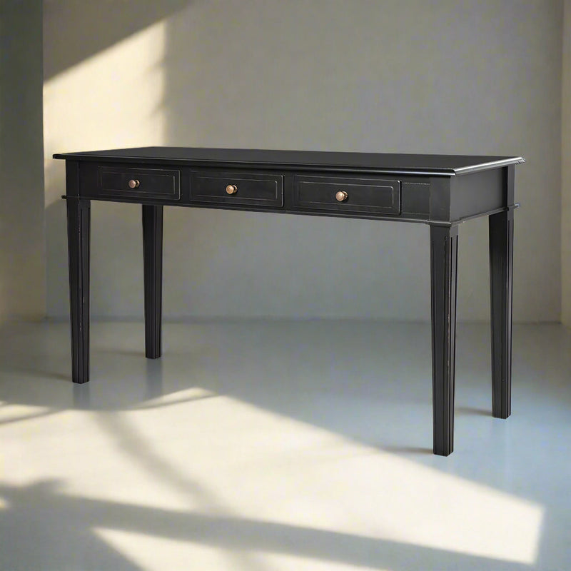 A black painted console table with three drawers, narrow enough for a hall or entryway with a mirror above.&nbsp; A definite statement in the black colour in a living room, it&nbsp; would look stunning with a statement table lamp on the top of it.&nbsp; Made of poplar wood this piece is sturdy and has copper handles to the drawers to add a touch of luxury.