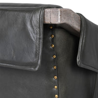 Close-up of a black leather jacket with wooden collar and brass buttons.