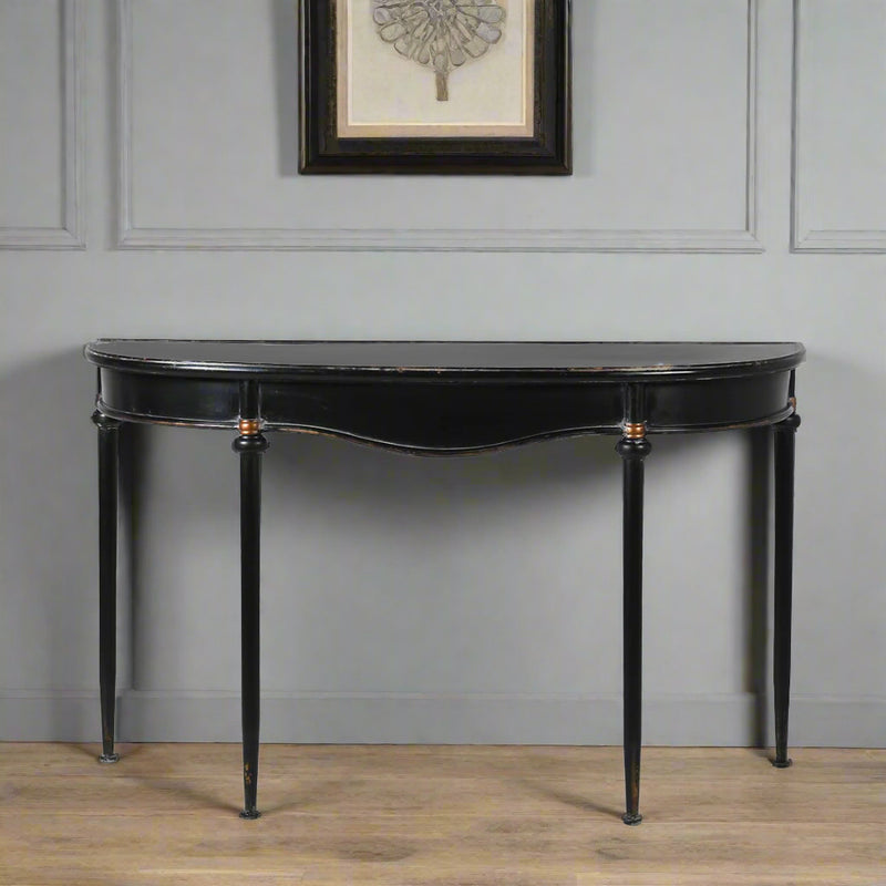 Refined, versatile, and effortlessly elegant, this medium metal console table is the perfect accent piece for modern and traditional interiors alike. Designed with a slim black metal frame and a gracefully curved silhouette, it offers a sophisticated focal point while keeping your hallway or entryway light and uncluttered.
The gently distressed black finish with delicate gold accents adds a touch of vintage character, making each piece feel unique.