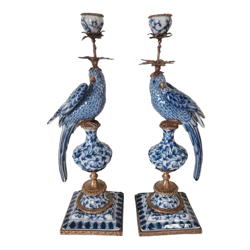 Pair of decorative candle holders with blue and white parrot design on a white background