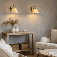 Living room with a wooden side table, beige armchair, and wall sconces.