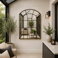 A great arched metal window mirror in an antique brass finish with studding to the frame. 