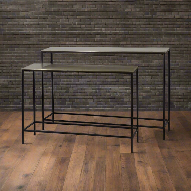 Sleek and sophisticated, this set of bronze-topped console tables pairs a warm metallic finish with minimalist black steel frames for a refined industrial look. The nesting design offers flexible styling — use together for layered depth or separately across your home. Perfect for entryways, living rooms, or modern interiors, these tables bring timeless elegance and functional versatility to any space