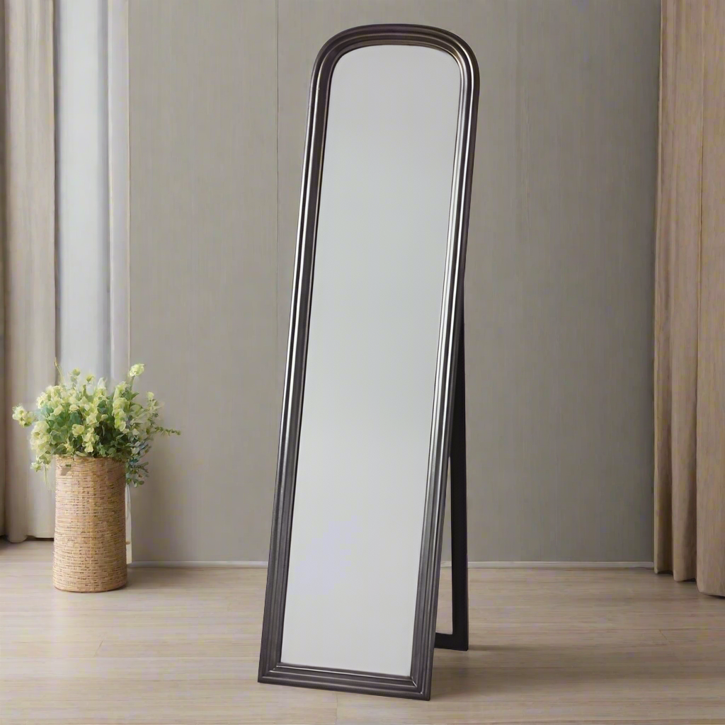 Brushed brass cheval mirror in a bedroom