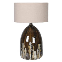 Large glazed ceramic table lamp in brown and cream tones with a neutral fabric drum shade, shown against a plain background.