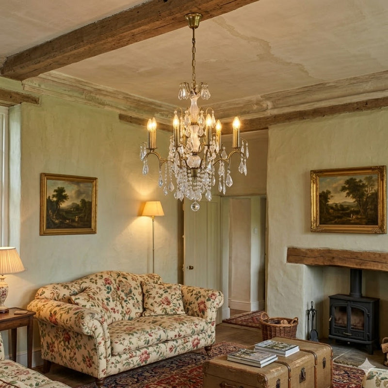 Living room with floral sofa, chandelier, and fireplace.