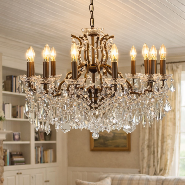 Large 12 branch crystal chandelier, close up in a living room with sofa and bookcases.