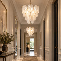 Two leaf chandeliers lighting a long hallway.