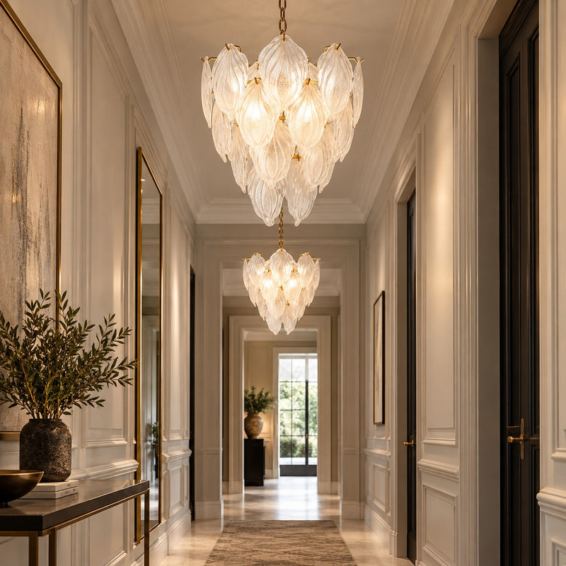 Two leaf chandeliers lighting a long hallway.