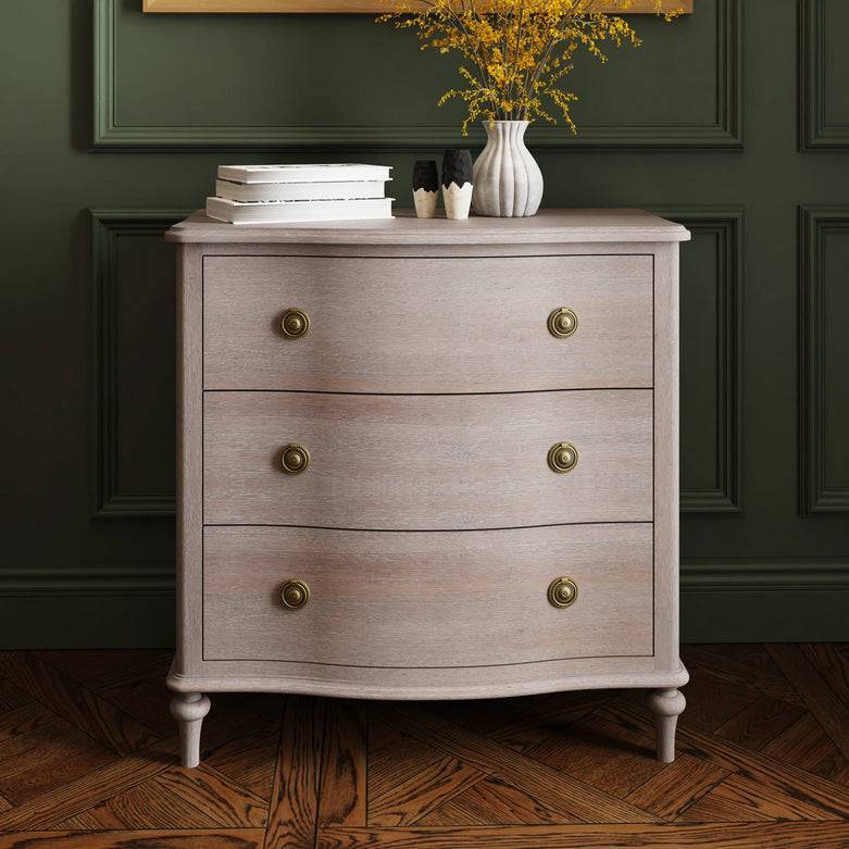 Soft off white wooden three drawer chest with brass knobs, elegant storage solution in a classic bedroom or living room setting