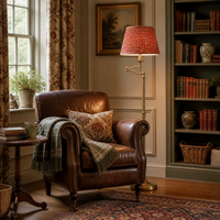 Reading nook with extending arm floor lamp and red patterned shade. 