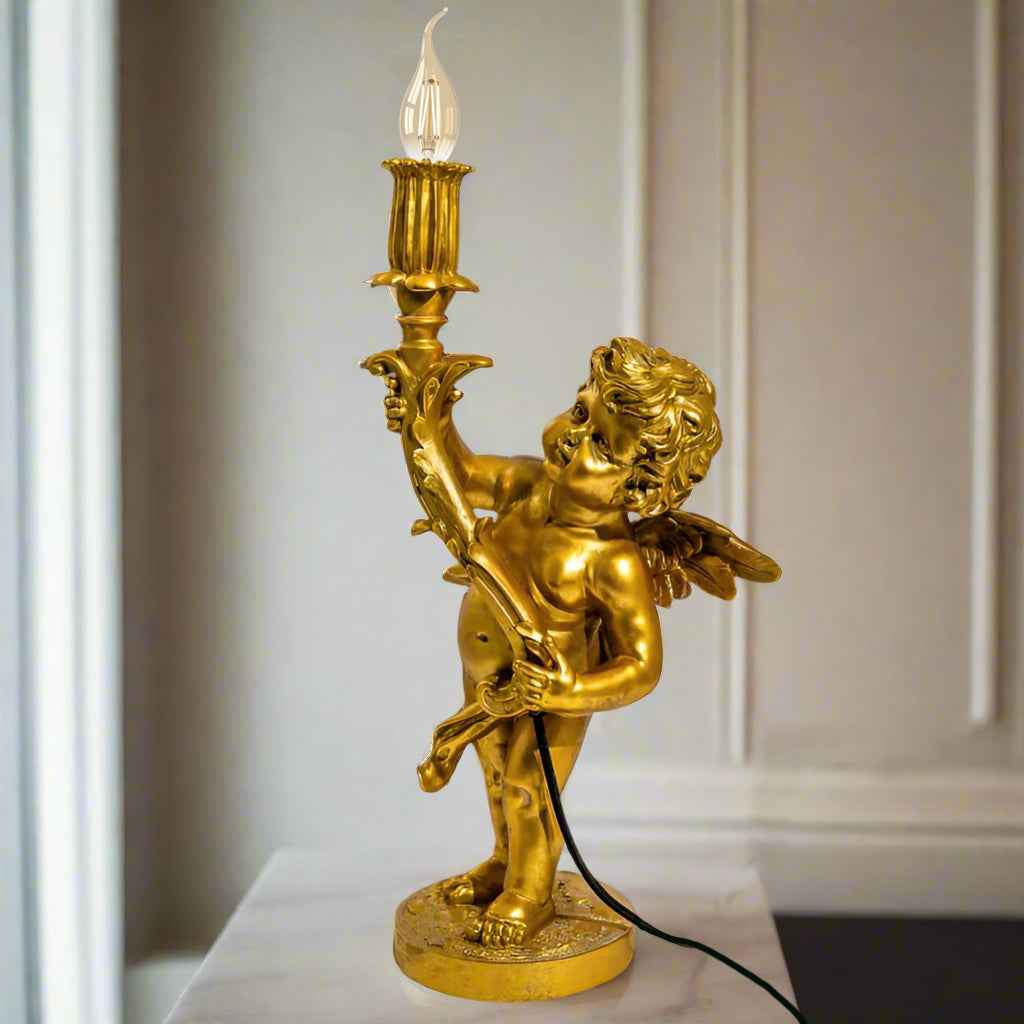 Gold cherub table light, perfectly formed cherubim hand outstretched holding a lamp.&nbsp; The lamp looks best with the addition of a filament bulb to add a glow.&nbsp; The lamp has a rococo decorative style working well in a luxurious bedroom, baroque styled living room - anywhere you need a touch of glamour.&nbsp; &nbsp;So decorative but also perfectly functional.&nbsp;&nbsp;