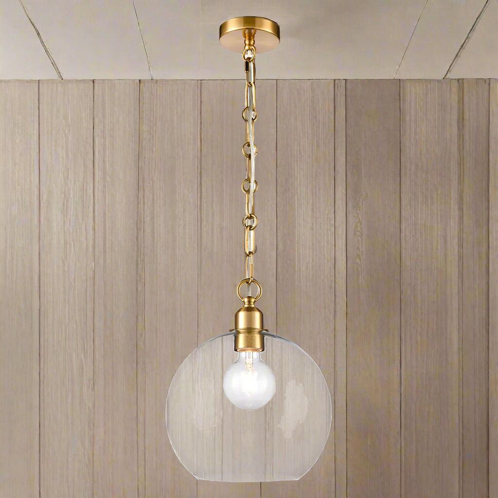 Clear glass pendant light with decorative gilt brass chain hanging from ceiling