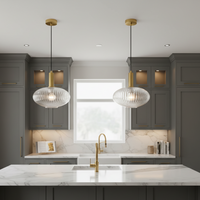 Modern kitchen with gray cabinets, marble countertops, and gold fixtures.