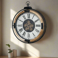 A wall clock with a black metal and wooden rim, featuring an antiqued cream face and moving cogs in the center, displayed on a wall.