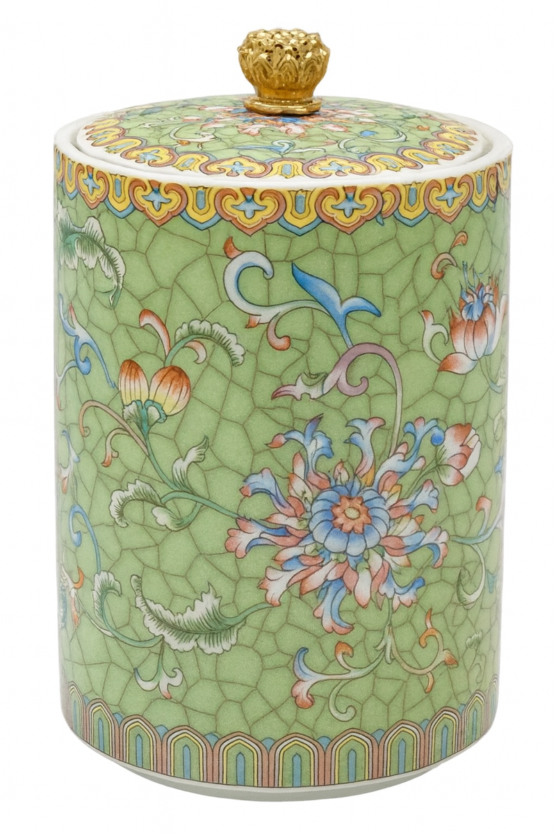 Handcrafted green ceramic scented candle jar with gold detailing and floral pattern, scented with warm amber, florals, and woods.