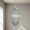 A teardrop-shaped pendant light with a nickel finish and crystal embellishments, hanging in a room.
