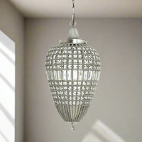 A teardrop-shaped pendant light with a nickel finish and crystal embellishments, hanging in a room.