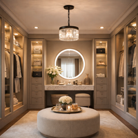 Luxurious walk-in closet with round mirror, chandelier, and round ottoman.